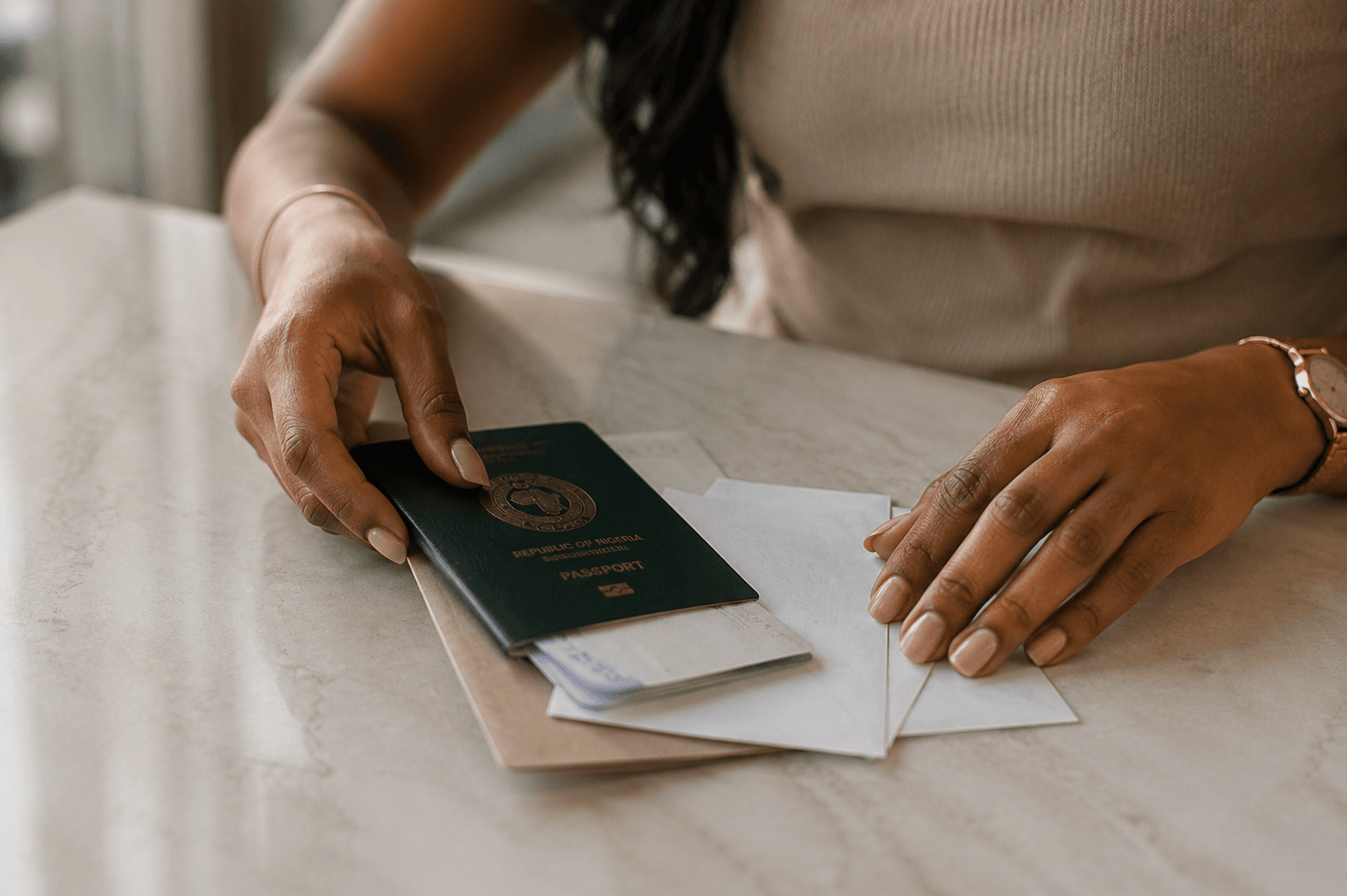 Hands holding an open passport above a document on a table.