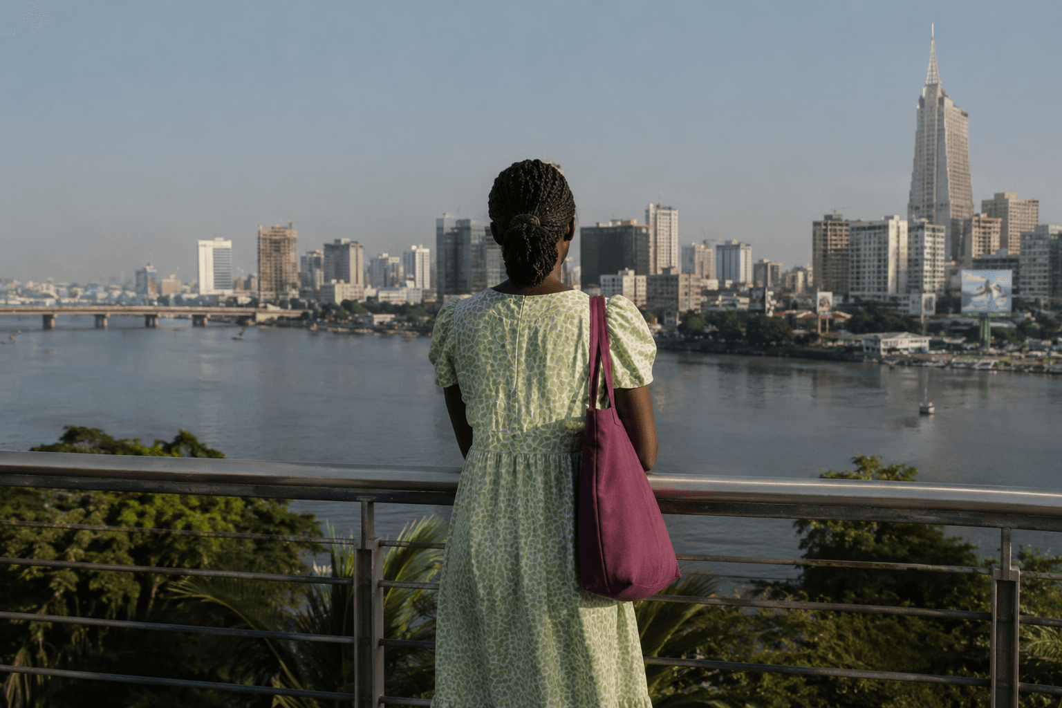 A woman looking out across water toward a city skyline.