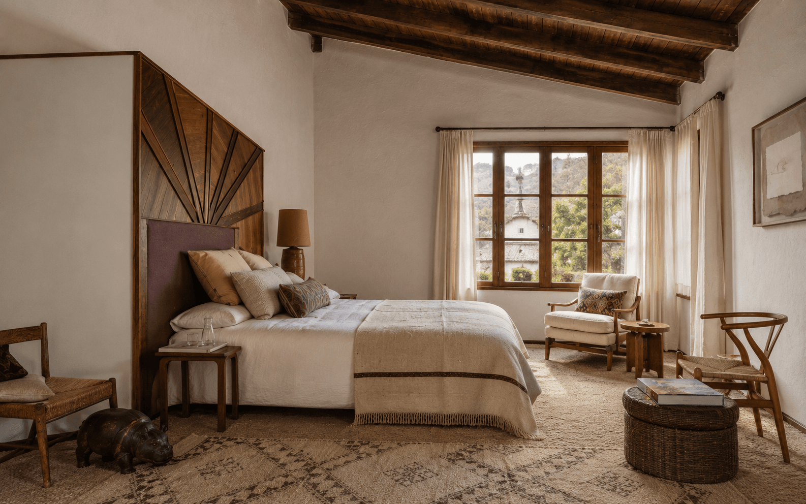 A quiet hotel bedroom in warm daylight, bed made, shutters half open.